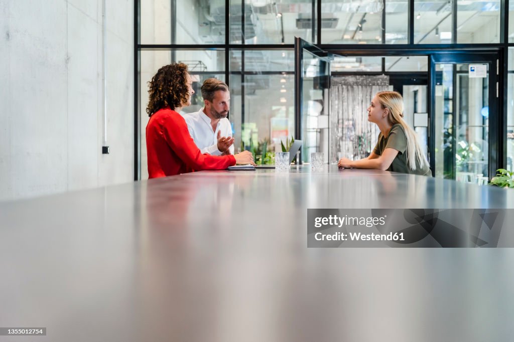 Recruiters having discussion with candidate at conference table