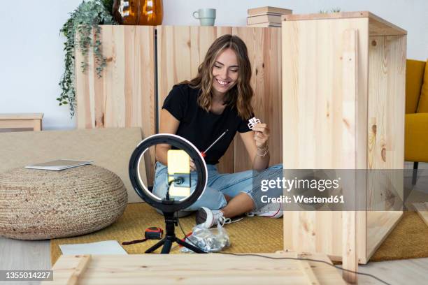 smiling female influencer with screwdriver assembling furniture - side hustle stock pictures, royalty-free photos & images