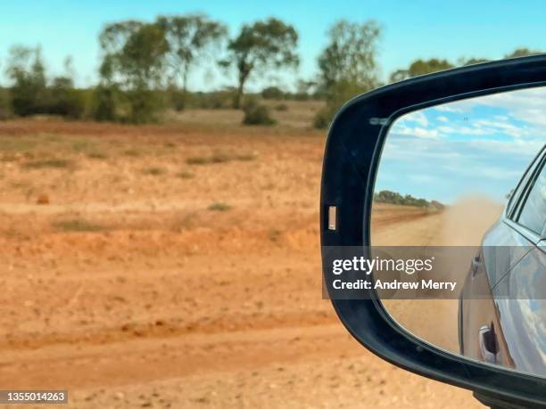 car side view mirror, red dirt road in country outback australia - driving car australia road copy space sunlight travel destinations colour image day getting stock pictures, royalty-free photos & images
