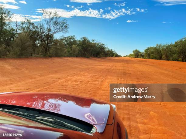 car driving on red dirt road in country outback australia - motorhaube stock-fotos und bilder