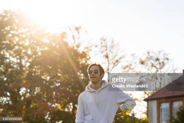 young man wearing sunglasses at backyard - sunny backyard stock pictures, royalty-free photos & images