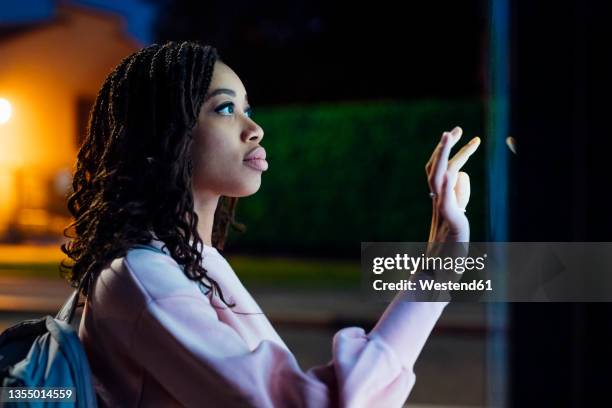 woman using kiosk at night - touchscreeen stock pictures, royalty-free photos & images