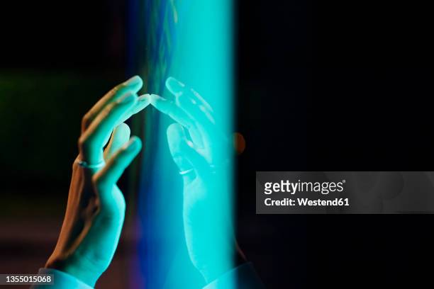 woman touching kiosk screen at night - touch screen technology foto e immagini stock