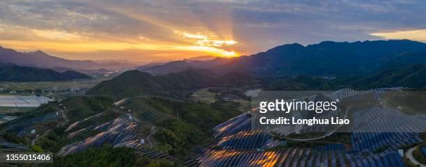 aerial shot of a solar photovoltaic plant on a mountaintop at dusk - development summit stock pictures, royalty-free photos & images