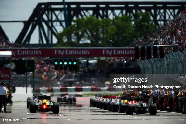 German Red Bull Racing Formula One racing driver Sebastian Vettel leads the field of drivers and cars in his RB9 racing car away from the grid to...