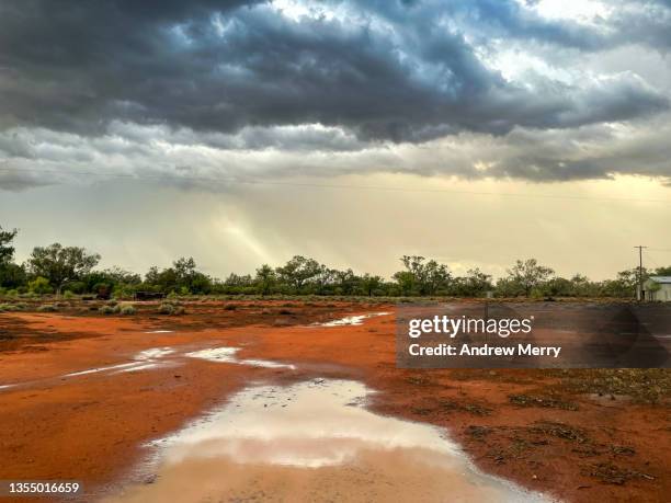 dark storm clouds, rain water on red dirt farm australia - extreme weather desert stock pictures, royalty-free photos & images