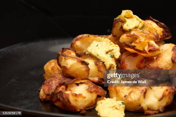 roast potatoes w. cafe de paris butter - gepofte-aardappel stockfoto's en -beelden