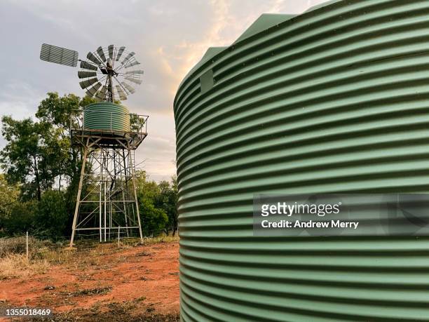 windmill and water storage tanks in rural australia - outback windmill stock pictures, royalty-free photos & images