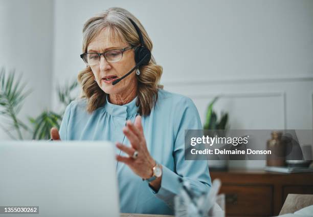 aufnahme einer reifen frau mit headset und laptop in einem modernen büro - hotline stock-fotos und bilder