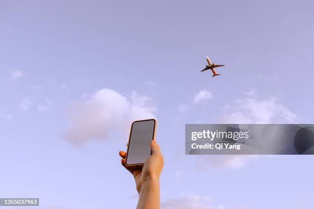close-up of using smartphone at sunset - aircraft wifi stock pictures, royalty-free photos & images
