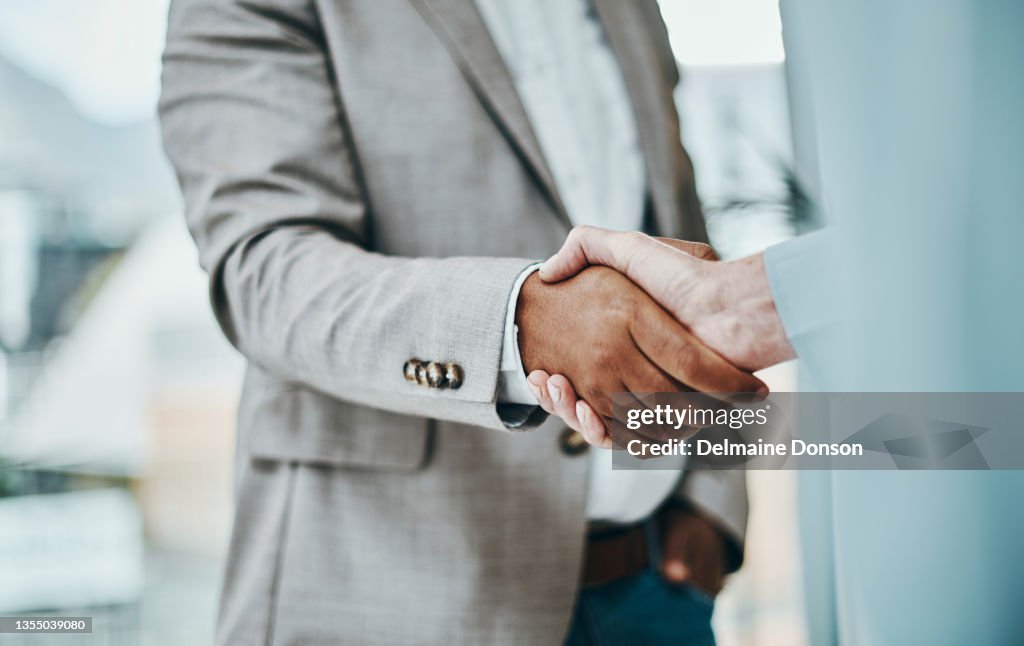 Scatto di un uomo d'affari e di una donna d'affari che si stringono la mano in un ufficio moderno