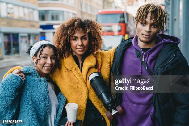 porträt von drei hippen freunden in london, die sich gemeinsam umarmen - sweatshirt stock-fotos und bilder