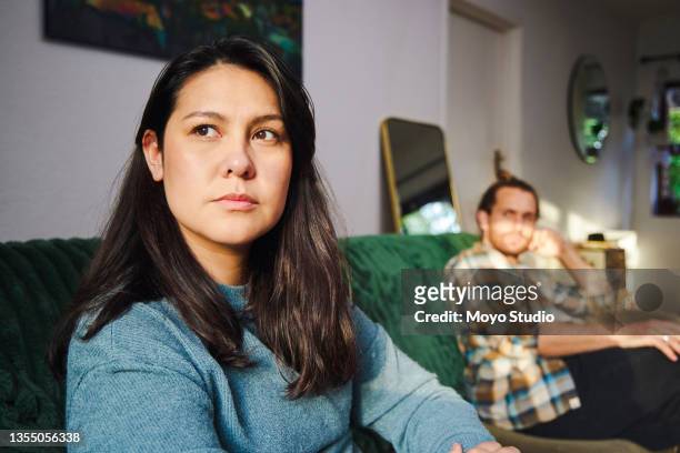 photo recadrée d’une jeune femme attirante qui a l’air agacée après s’être disputée avec son petit ami qui est assis en arrière-plan - rejet photos et images de collection