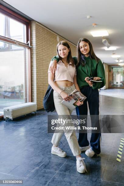 two students walking to class together - sólo chicas adolescentes fotografías e imágenes de stock