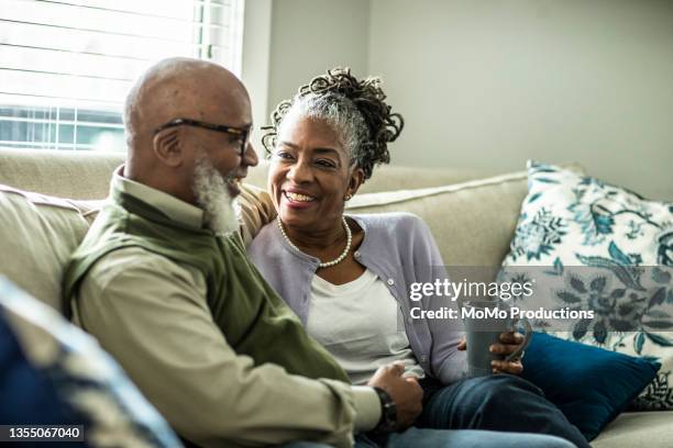 senior couple talking in living room of suburban home - coffee moustache stock pictures, royalty-free photos & images