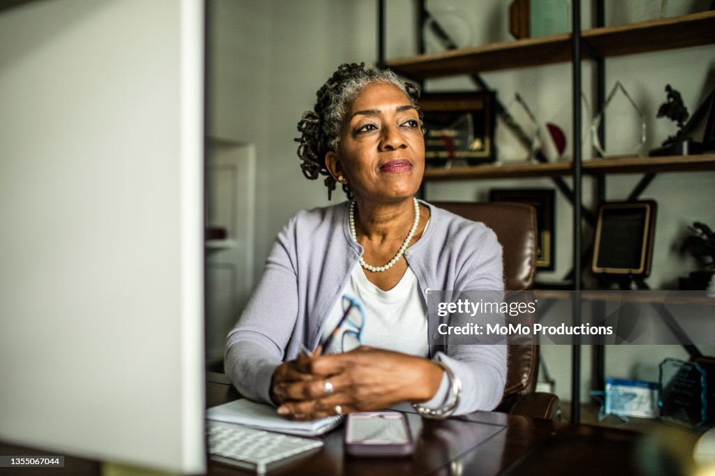 Portrait of senior woman at desktop computer in home office