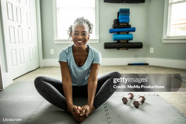 senior woman exercising in home gym - yoga pose photos et images de collection