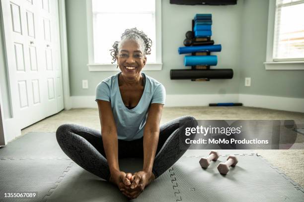 senior woman exercising in home gym - senior adult yoga stock pictures, royalty-free photos & images