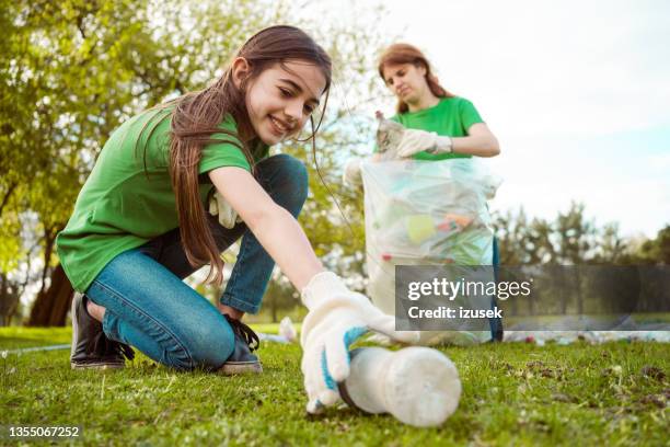 bénévoles ramassant les déchets dans le parc - action climatique photos et images de collection