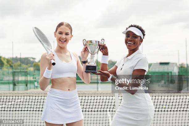 shot of two attractive women standing together and holding a trophy after playing tennis - championship day two stock pictures, royalty-free photos & images