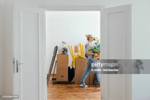 eine anonyme frau zieht in neue wohnung ein - man boxes moving home stock-fotos und bilder