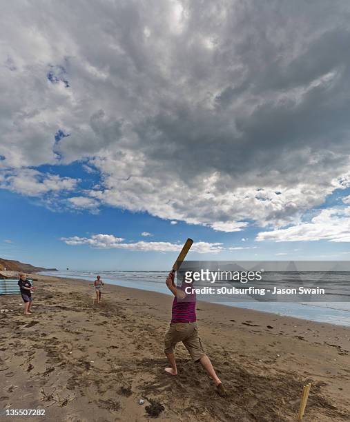 fanily playing cricket at beach - beach cricket stock pictures, royalty-free photos & images