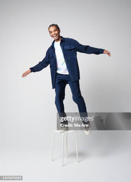 fashionable businessman balancing on stool - men balancing stock pictures, royalty-free photos & images