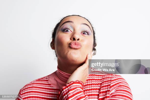 portrait of young woman with playful expression - puckering stock pictures, royalty-free photos & images
