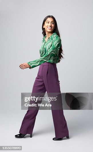 Gen Z business woman walking and looking over shoulder Gen Z business woman walking and looking over shoulder