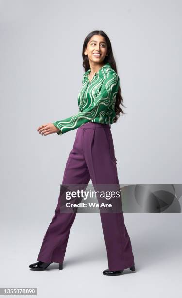gen z business woman walking and looking over shoulder - andar imagens e fotografias de stock