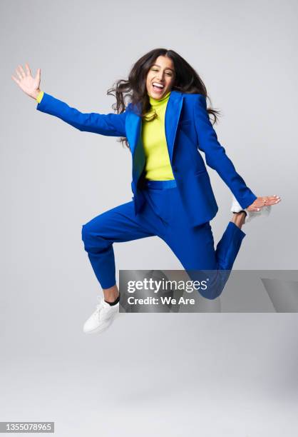 smartly dressed gen z woman jumping - business blue stock-fotos und bilder