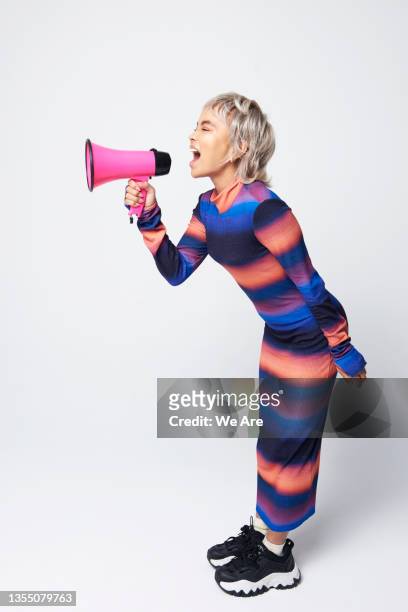 fashionable woman shouting into megaphone - megaphone - fotografias e filmes do acervo
