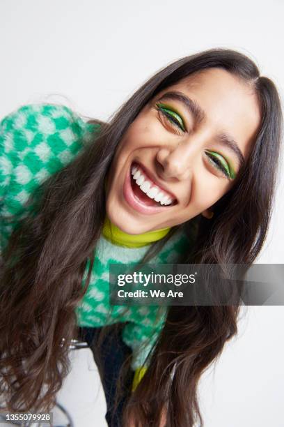 young fashionable woman leaning towards camera smiling - makeup smile laugh closeup female stock pictures, royalty-free photos & images