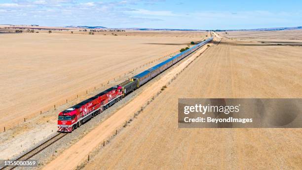 aerial view of the legendary ghan tourist train with red engines passing farmlands in northern south australia - darwin australia aerial stock pictures, royalty-free photos & images