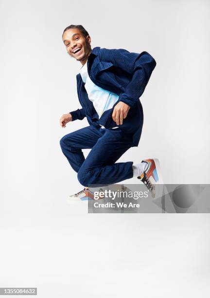 young man in suit jumping in studio - business mann ganzkörper freisteller stock-fotos und bilder