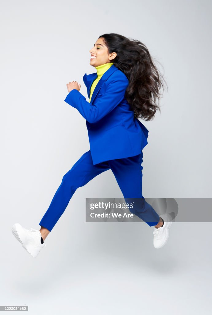 Smartly dressed Gen Z woman jumping