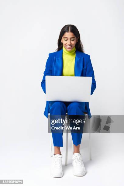 gen z woman in suit using laptop - woman white background foto e immagini stock