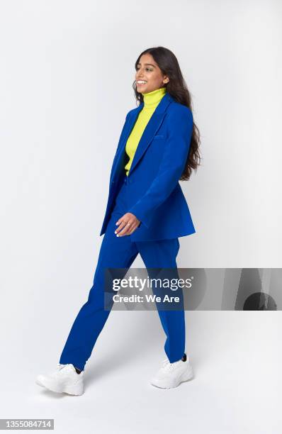 young business woman walking with a cheerful expression - women in suits stock pictures, royalty-free photos & images