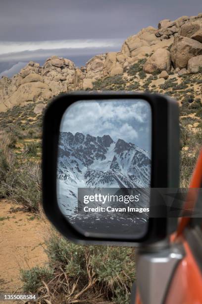 view of mountains in snow in car mirror, california, usa - bishop californie photos et images de collection