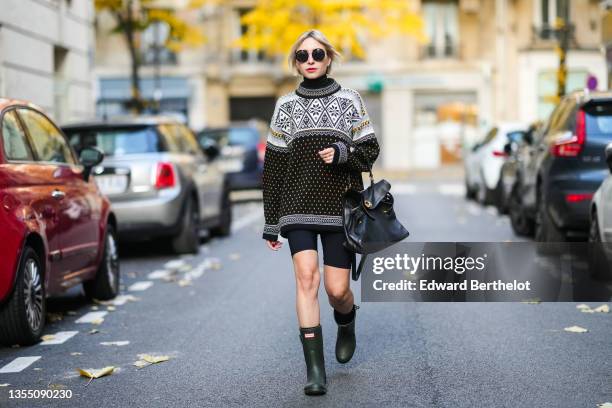 Emy Venturini wears black sunglasses from Linda Farrow & The Row, a white with black and yellow print pattern wool turtleneck vintage pullover, black...