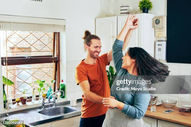 scatto di una giovane coppia che balla - couple in kitchen foto e immagini stock