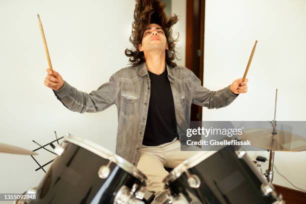 young man rocking out on the drums during a band rehearsal - headbanging stock pictures, royalty-free photos & images