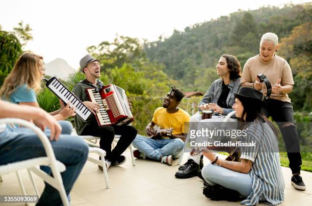 grupo diverso de miembros de la banda tocando afuera con una variedad de instrumentos - variety show fotografías e imágenes de stock