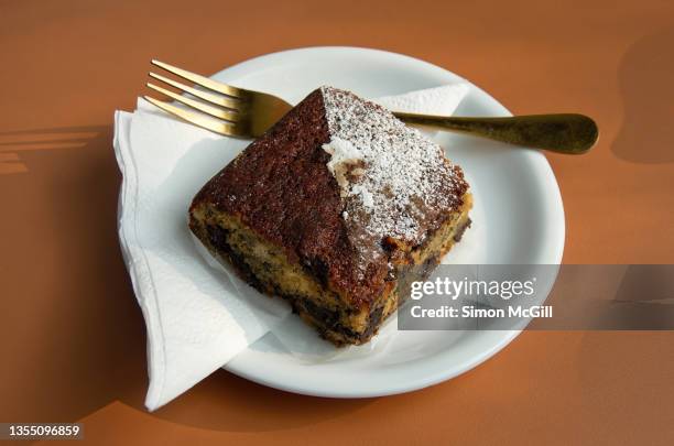 banana and chocolate chip bread on a white plate with a paper napkin at a sidewalk cafe - paper napkin stock-fotos und bilder
