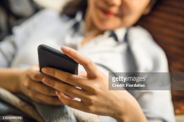 a middle-aged asian woman with mobile phone - hot vietnamese women stock pictures, royalty-free photos & images
