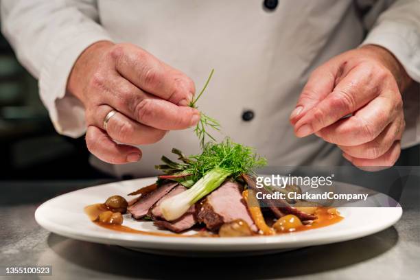 chef at the pass - hoofdgerecht stockfoto's en -beelden