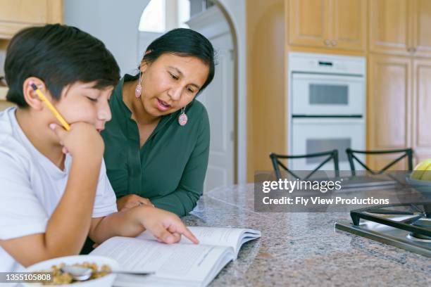 native american mom helping son with homework - american tribal culture stock pictures, royalty-free photos & images