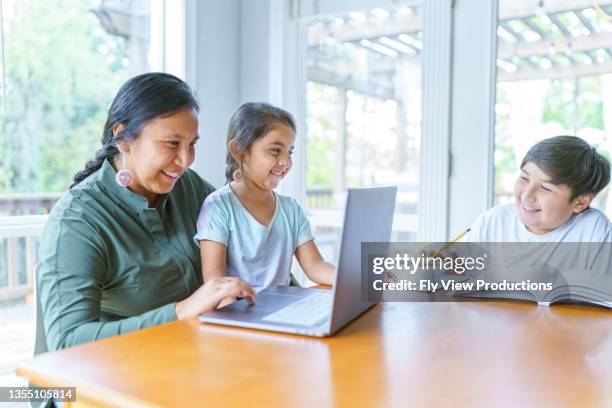 mom helping elementary age girl with e-learning video conference call - native american ethnicity stock pictures, royalty-free photos & images