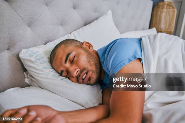 shot of a young man sleeping in a bed at home - good afternoon stock pictures, royalty-free photos & images