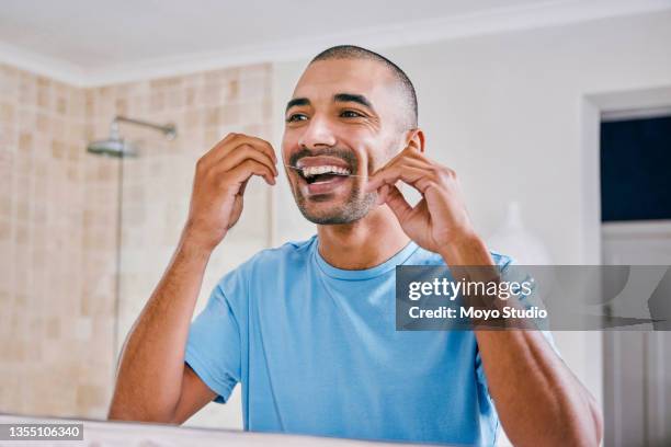 shot of a young man flossing his teeth in the bathroom at home - dental floss stock pictures, royalty-free photos & images